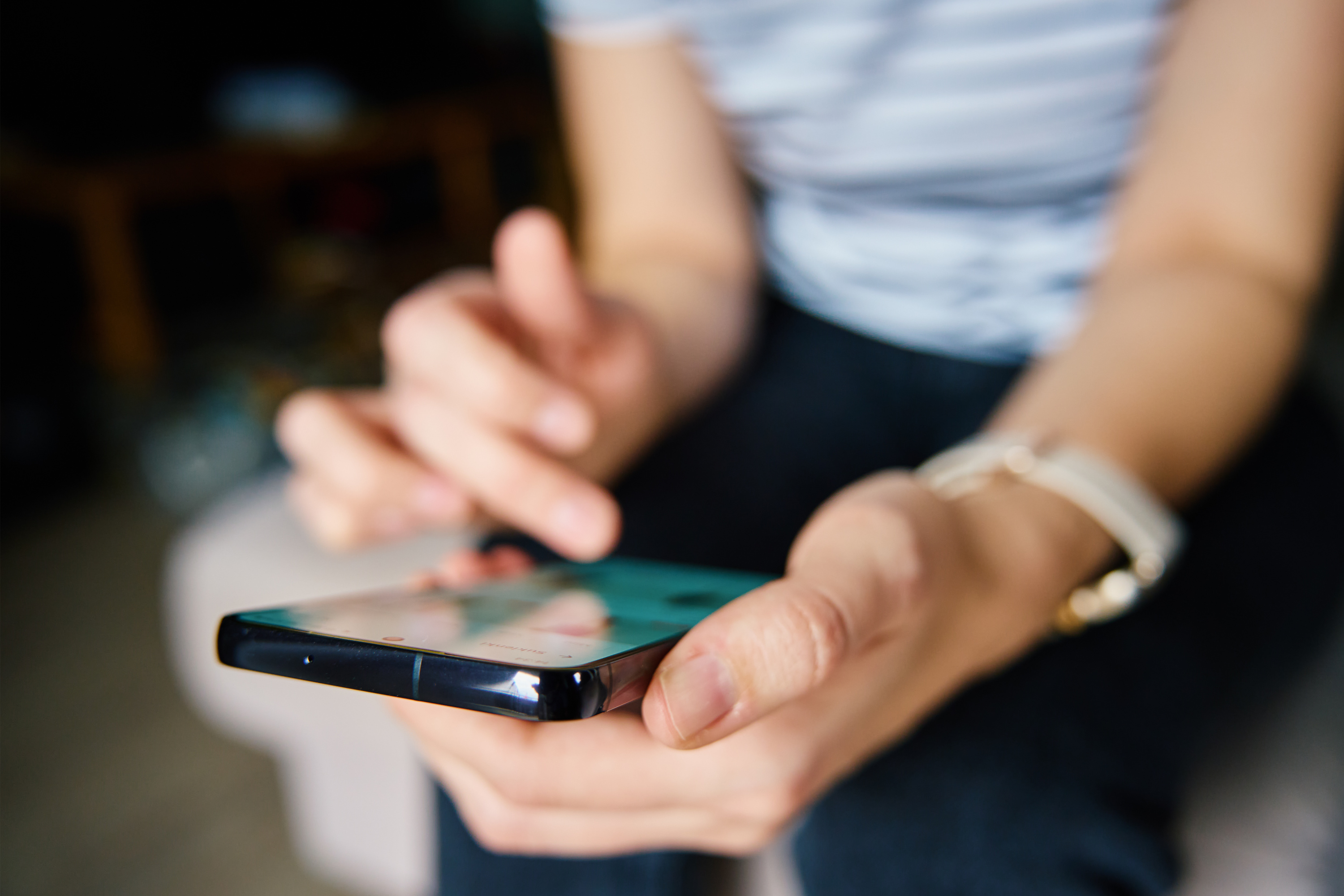 Person Browsing Social Media on Smartphone Indoors